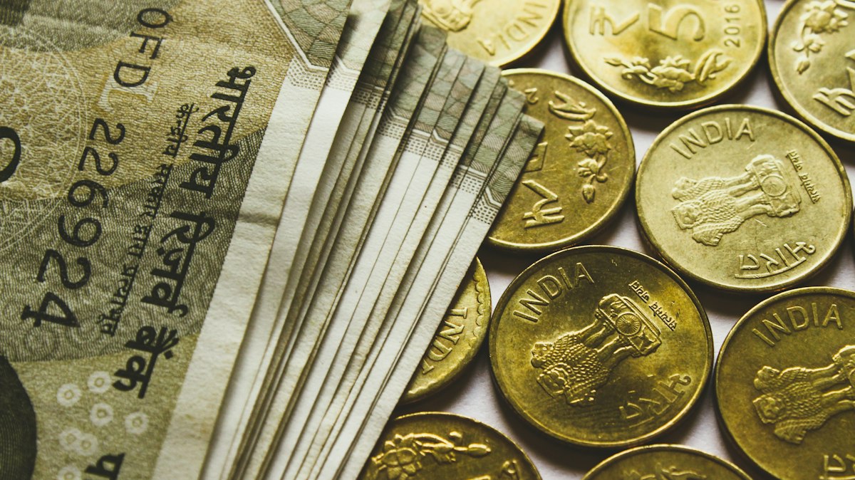 Yuvarlak altın renkli rupi madeni paraları ve banknotlar