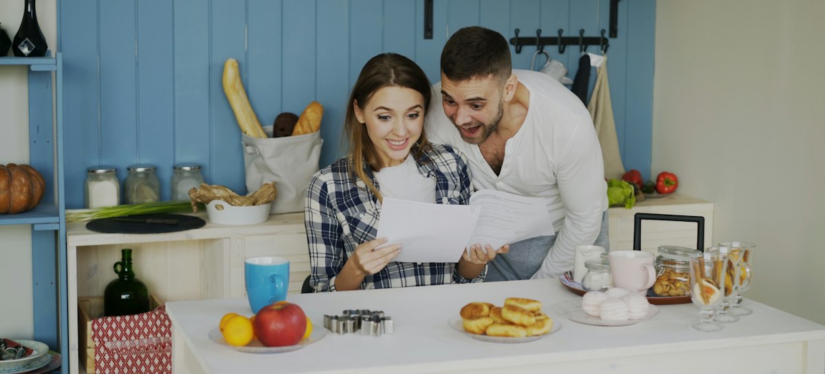 Mutfak masasında birlikte evrakları inceleyen bir çift